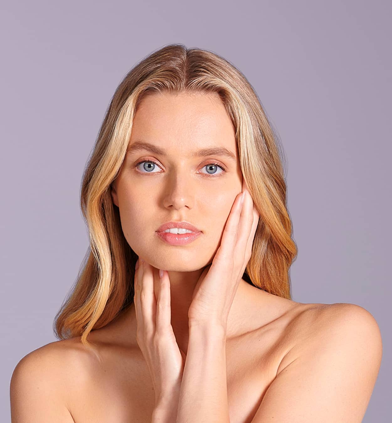 Close up of woman touching face with clear flawless skin